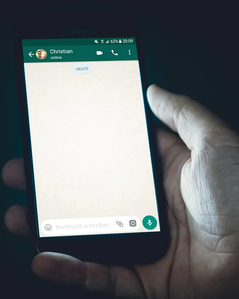 Main tenant un smartphone affichant une conversation