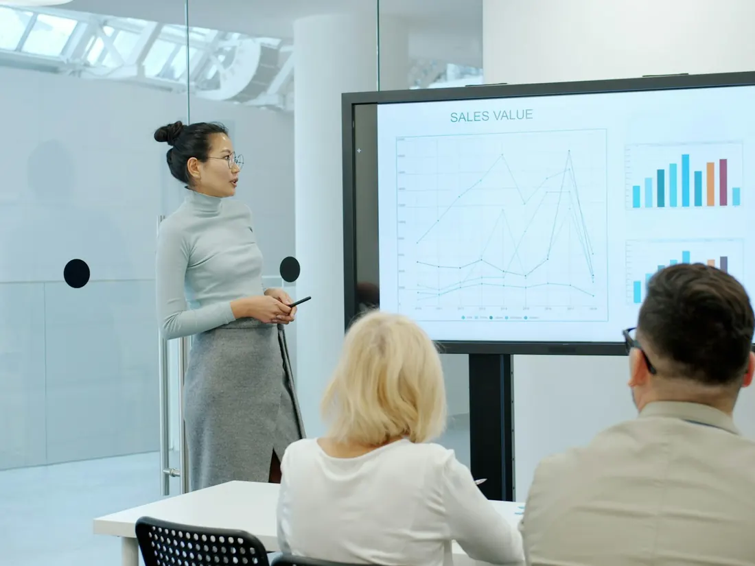 Une ingénieure présente un graphique de résultats à son équipe