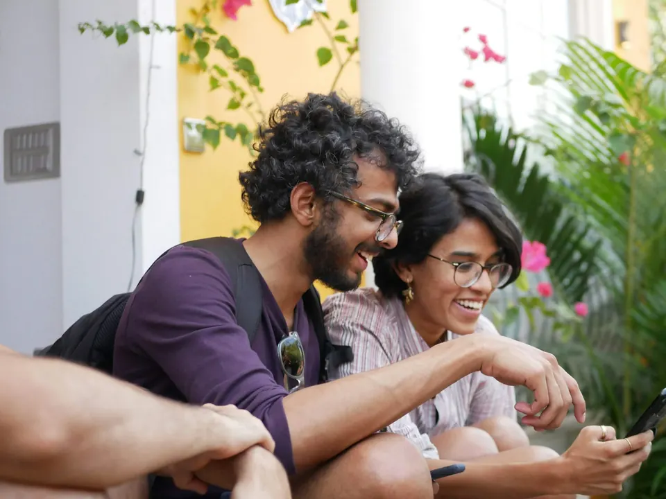Deux amis consultant un smartphone en souriant
