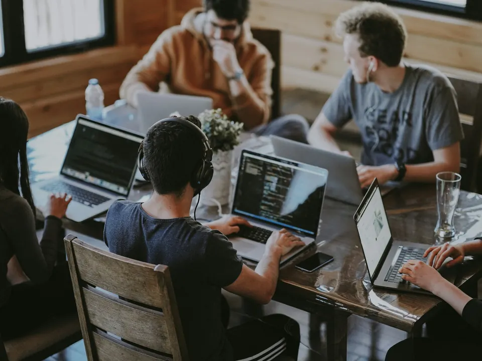 Jeunes professionnels travaillant ensemble sur des ordinateurs portables